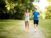 Junge Frau und junger Mann joggen gemeinsam draßen in der Natur.