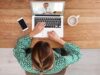 Junge Frau sitzt an ihrem Laptop und nimmt an Ernährungsberatung teil.