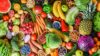 Viele verschiedene Sorten Obst und Gemüse liegen auf einem Tisch.