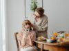 Teenager am Esstisch mit Handy